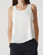 Regata off-white com babados, vista frontal destacando o caimento solto.