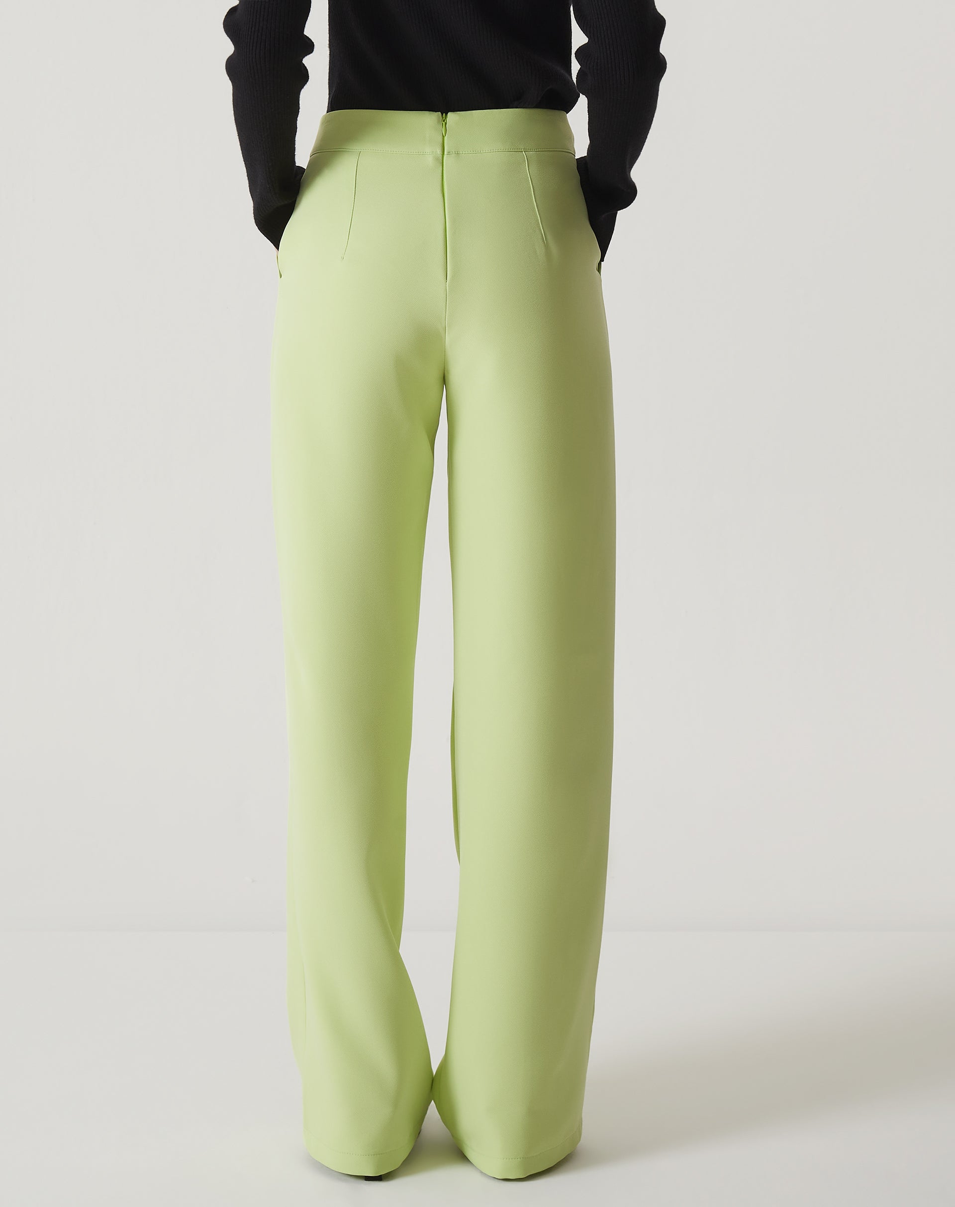Vista traseira da calça reta de alfaiataria verde claro.