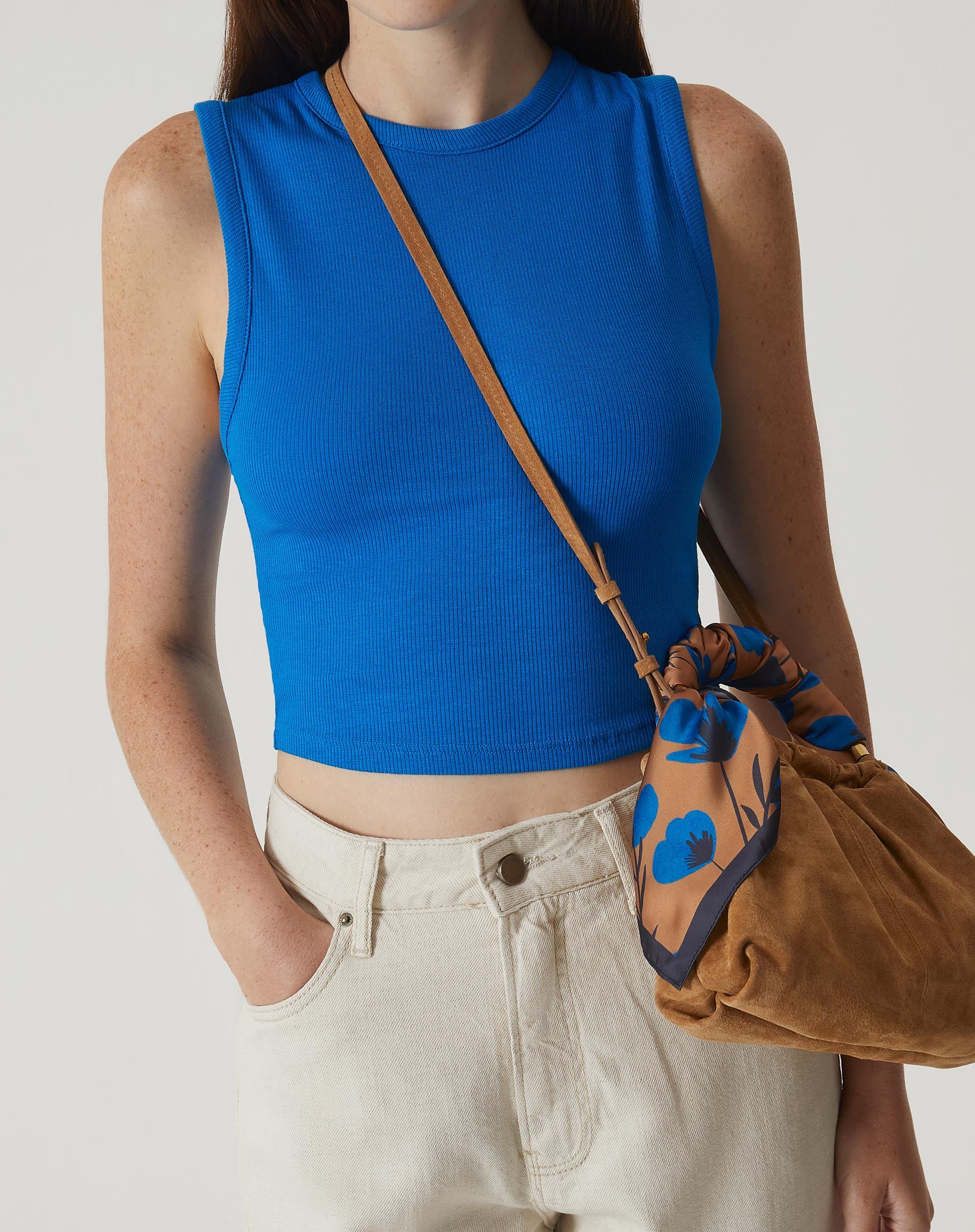 Regata curta de malha azul vista de frente, destacando o design minimalista e o decote gola.