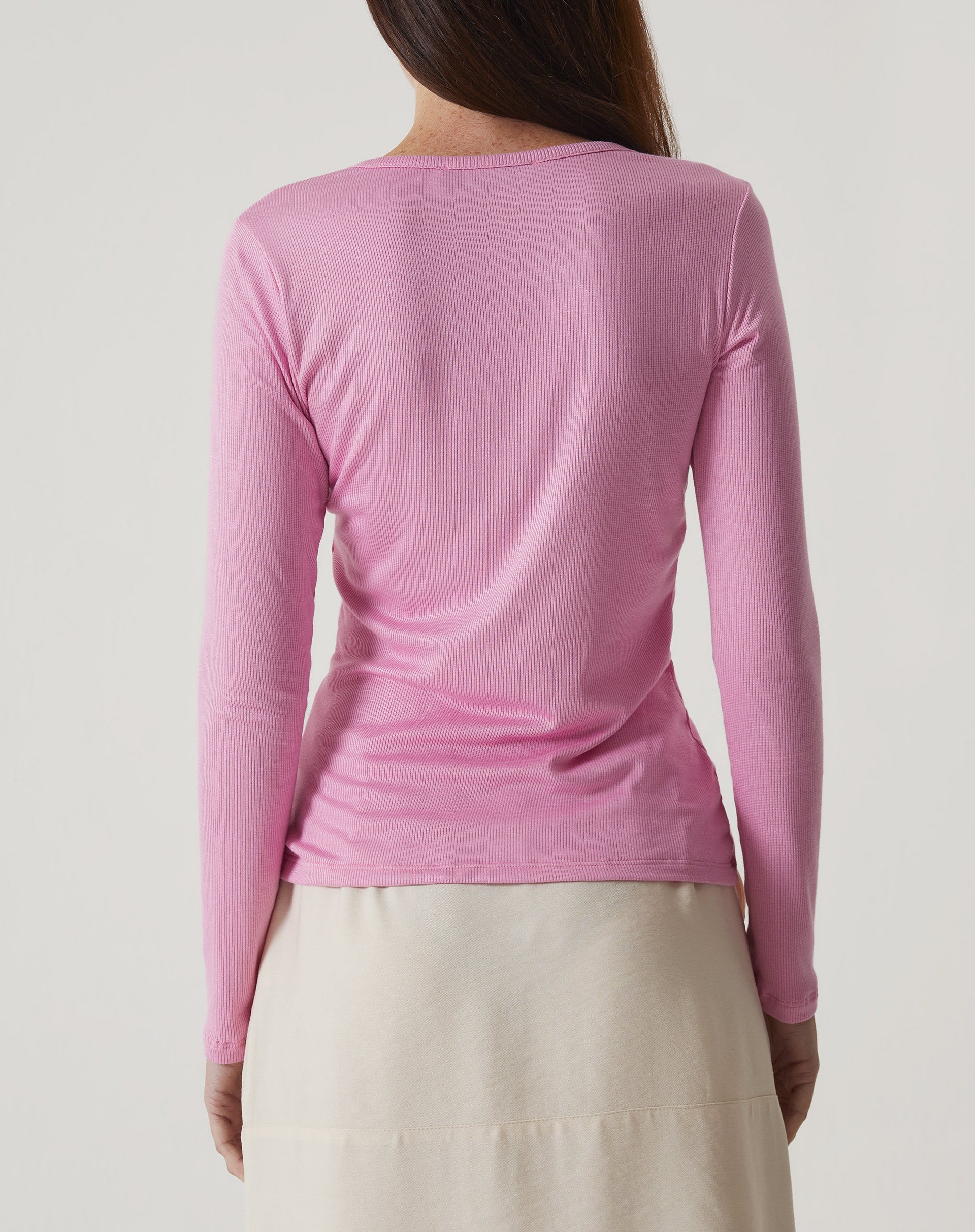 Vista traseira da blusa manga longa rosa mostrando o caimento.