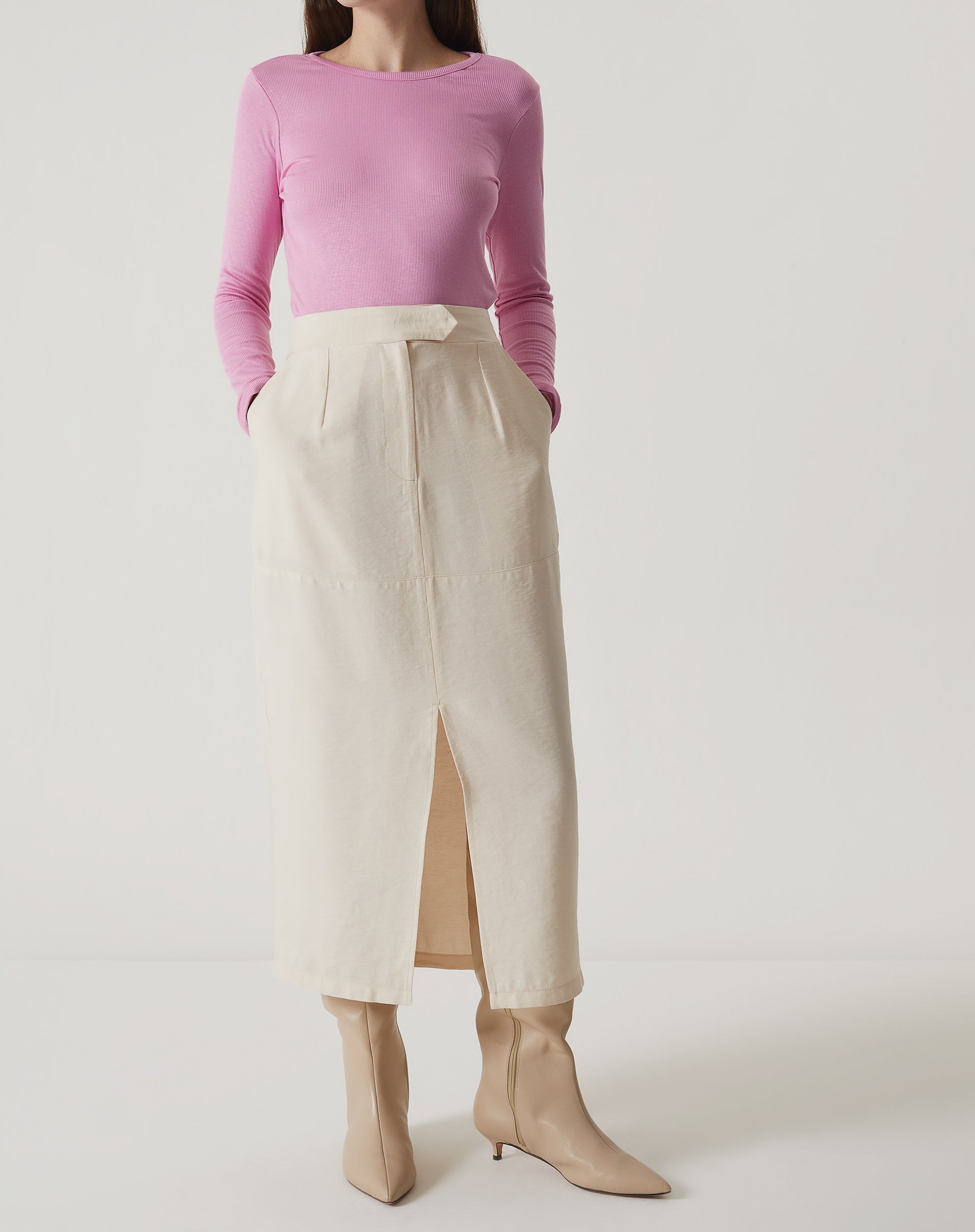 Blusa manga longa rosa combinada com saia midi branca, vista completa.