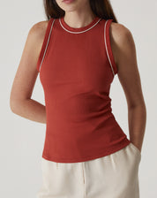 Vista lateral da Regata Slim de Malha em laranja, mostrando o ajuste ao corpo.