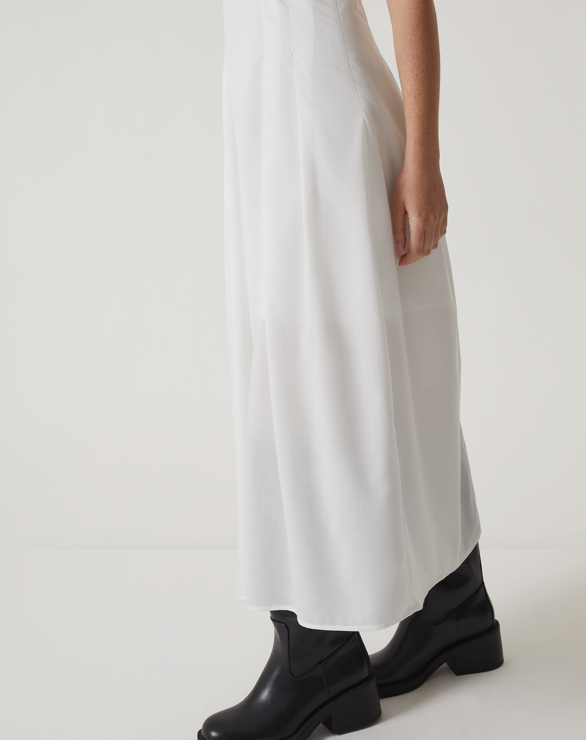Imagem de um vestido midi off-white de tricoline com decote reto e mangas curtas, visto de costas.