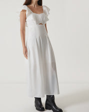 Imagem de um vestido midi off-white de tricoline com decote reto e mangas curtas, mostrando detalhes do tecido.