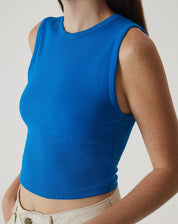 Close-up da regata curta de malha azul, evidenciando o tecido e o acabamento.