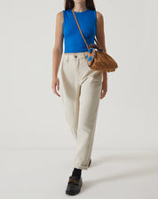 Modelo vestindo a regata curta de malha azul com calça clara, mostrando um look casual.