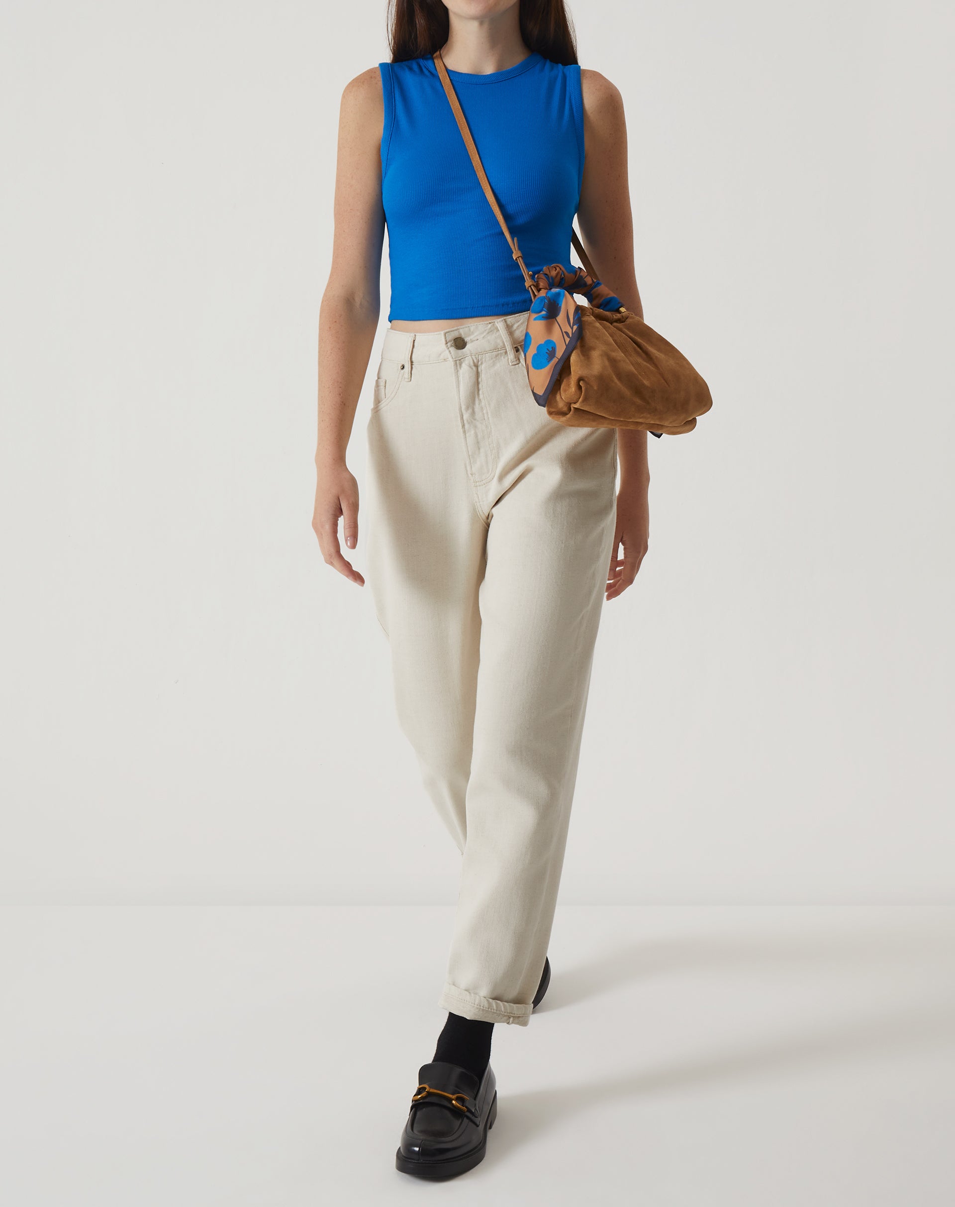 Modelo vestindo a regata curta de malha azul com calça clara, mostrando um look casual.