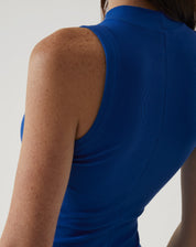 Close-up do vestido azul sem mangas, destacando o ajuste na parte traseira.