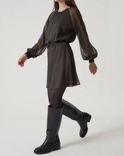 Vista lateral do vestido curto verde com mangas longas bufantes, destacando o caimento.