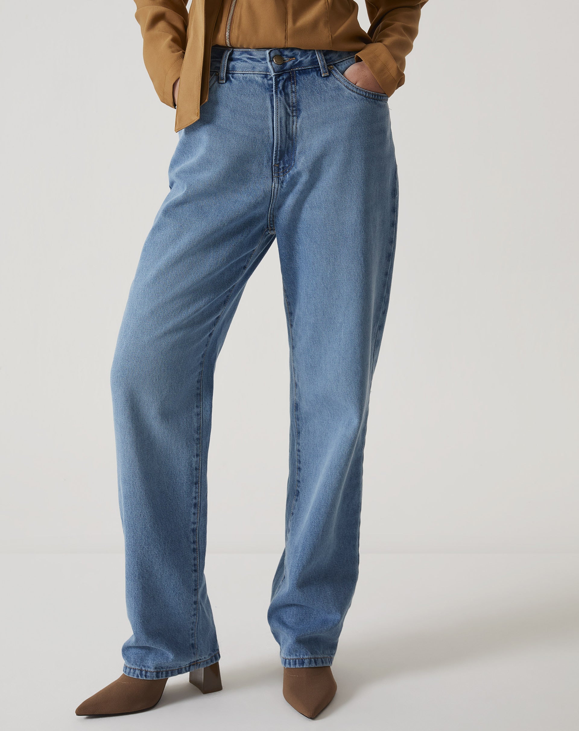 Vista lateral da calça jeans reta azul médio.