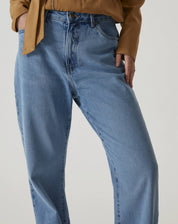 Detalhe da cintura alta da calça jeans azul médio.