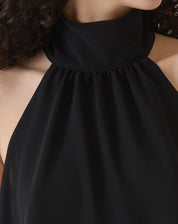 Close-up do decote alto da blusa frente única com transparência.