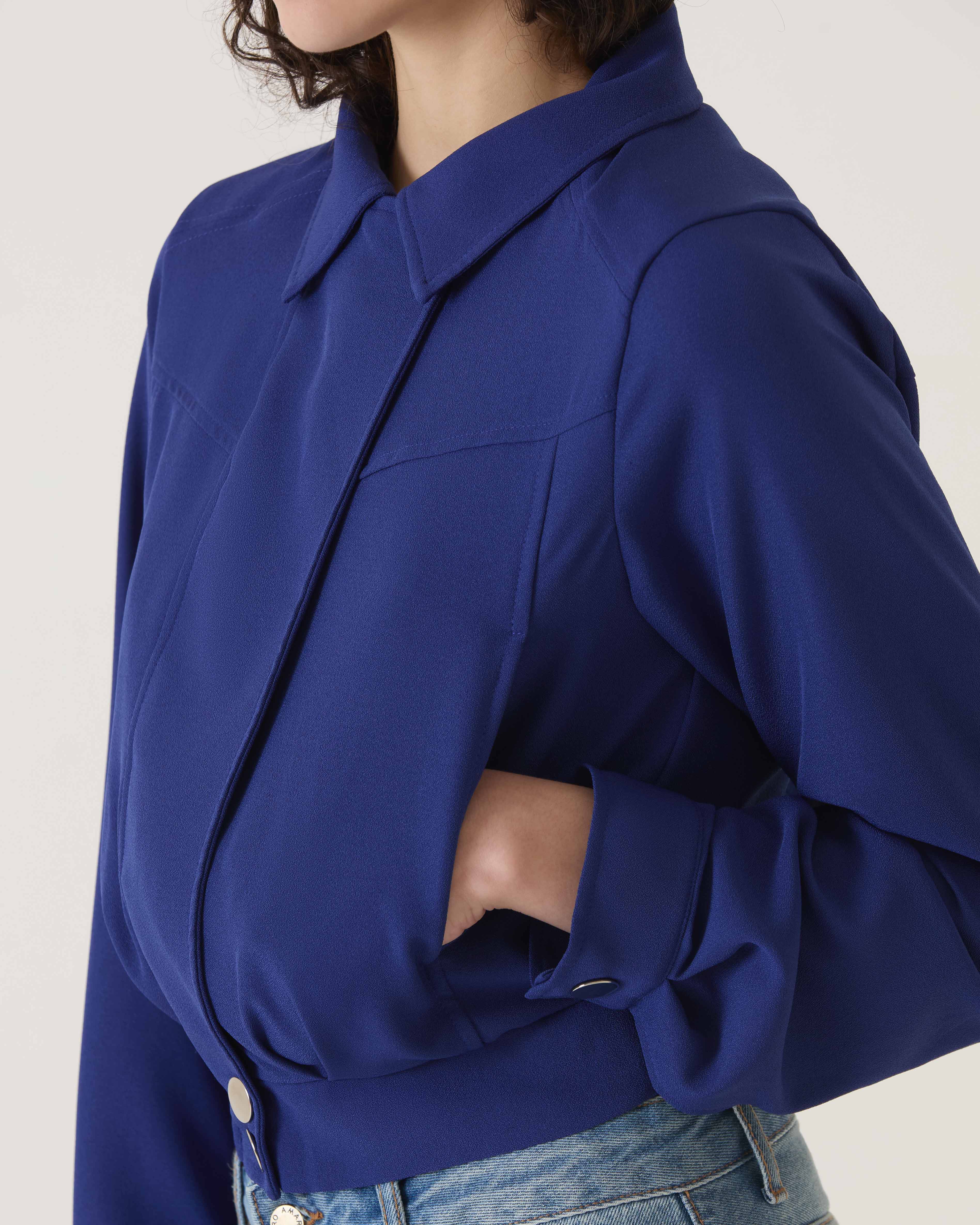 Close-up do colarinho clássico e acabamento da jaqueta azul escuro.