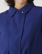 Vista traseira da jaqueta azul escuro mostrando o corte impecável e design minimalista.