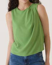 Modelo usando a blusa sem mangas de crepe verde, destacando o estilo casual e elegante.