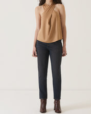 Vista completa da blusa bege com decote transpassado, combinada com calça jeans.