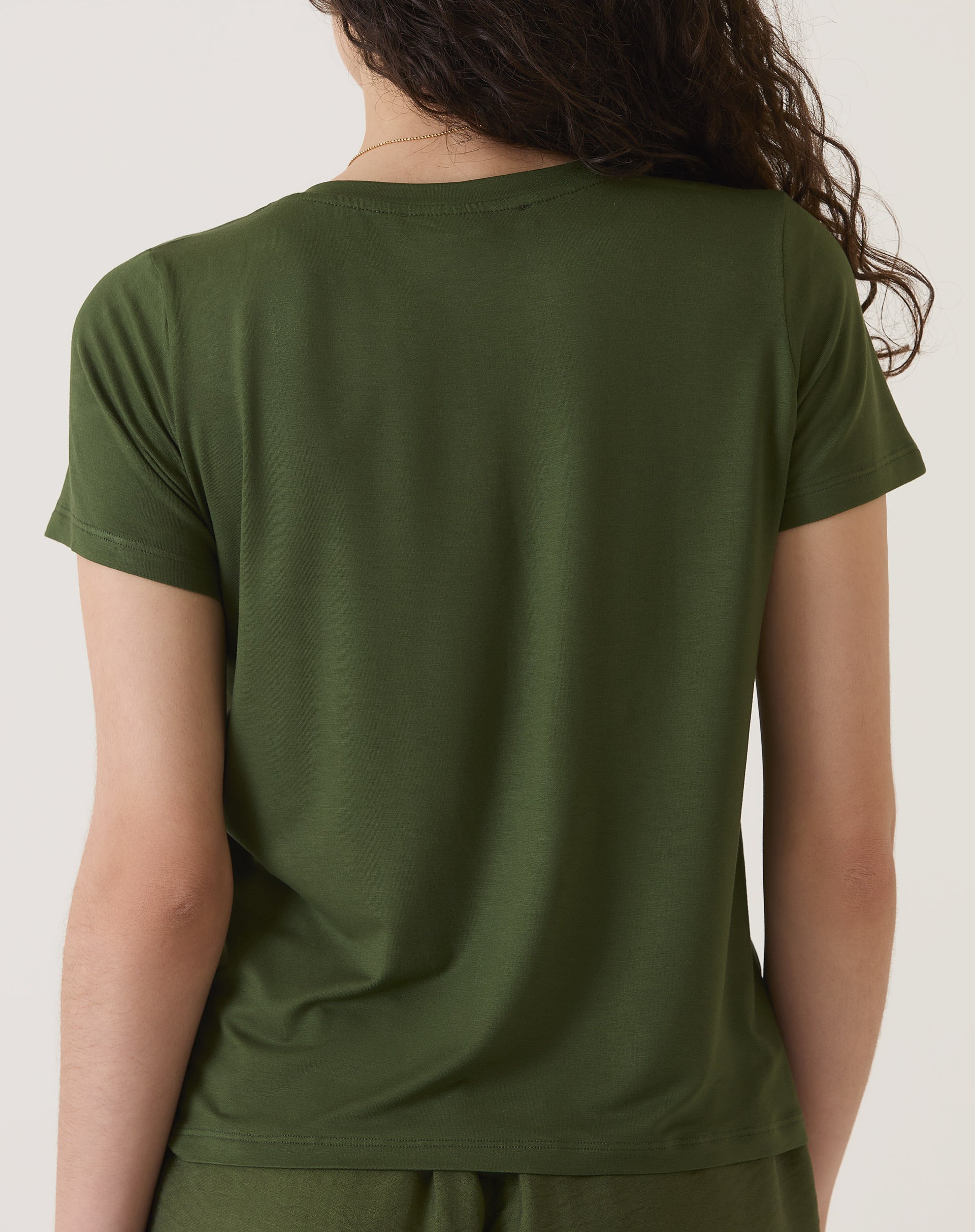 Vista traseira da camiseta verde, mostrando o design simples e elegante.