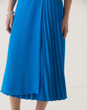 Close-up do tecido e pregas da saia azul.