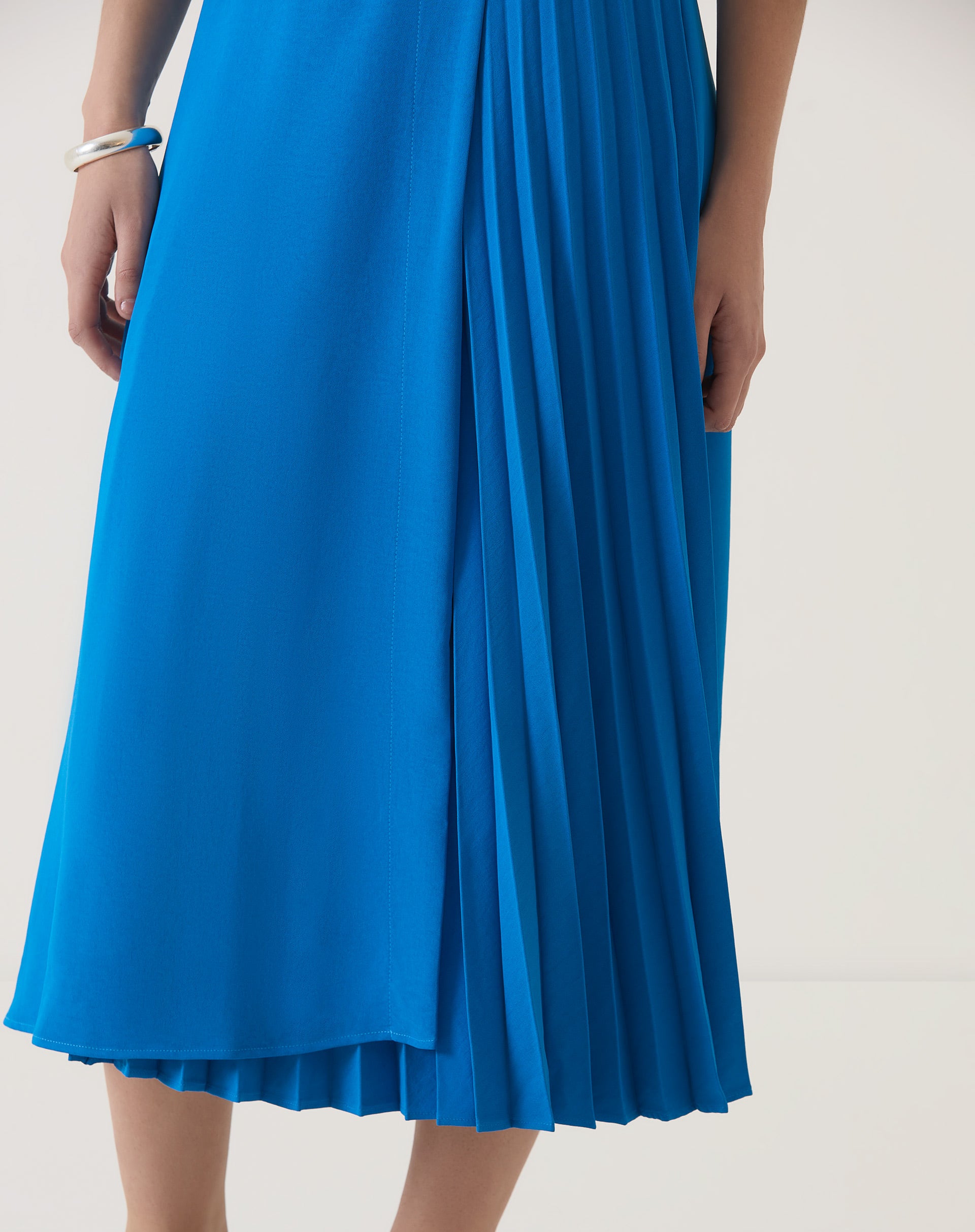 Close-up do tecido e pregas da saia azul.