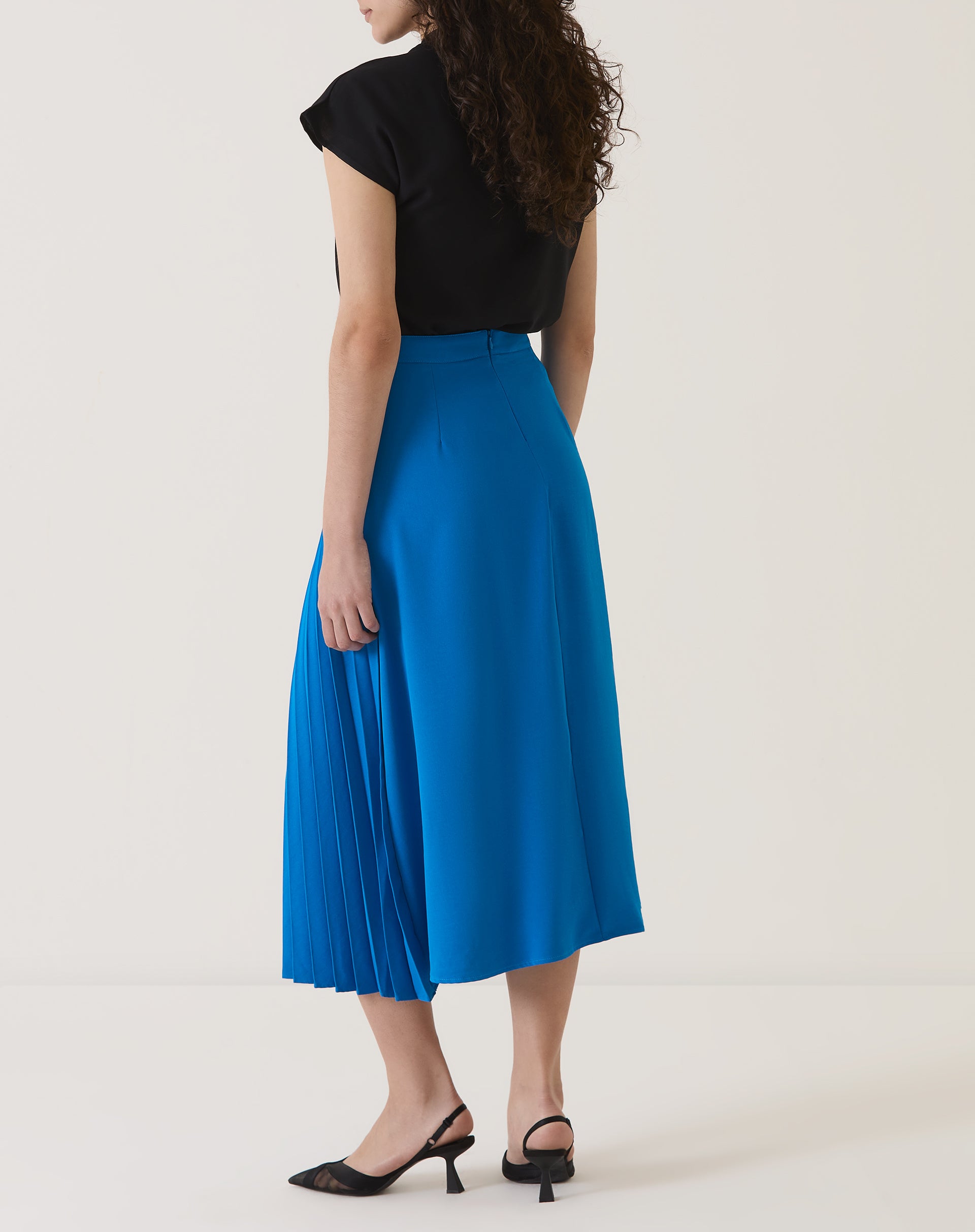 Detalhe das pregas da saia azul.