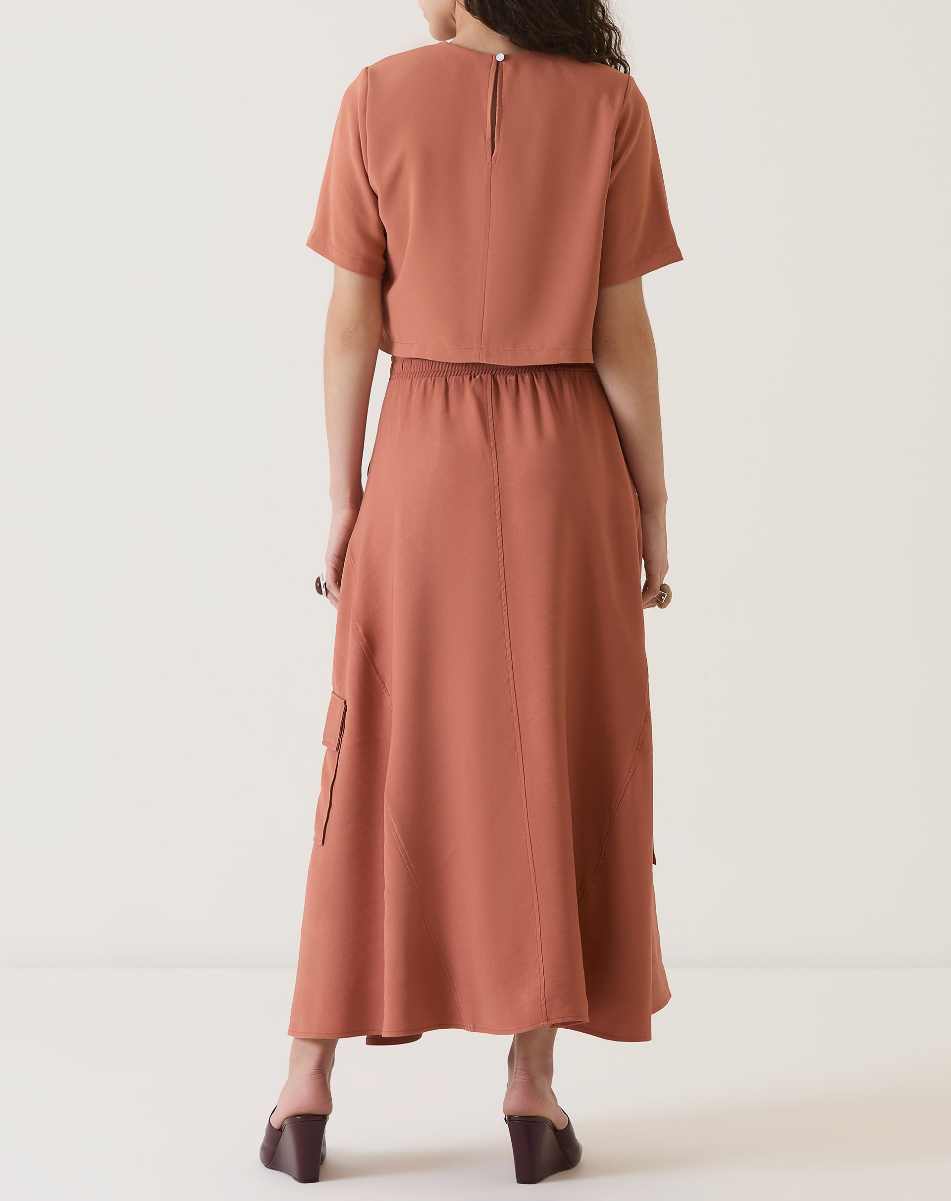 Vista traseira da saia midi bege, mostrando o design do cós.