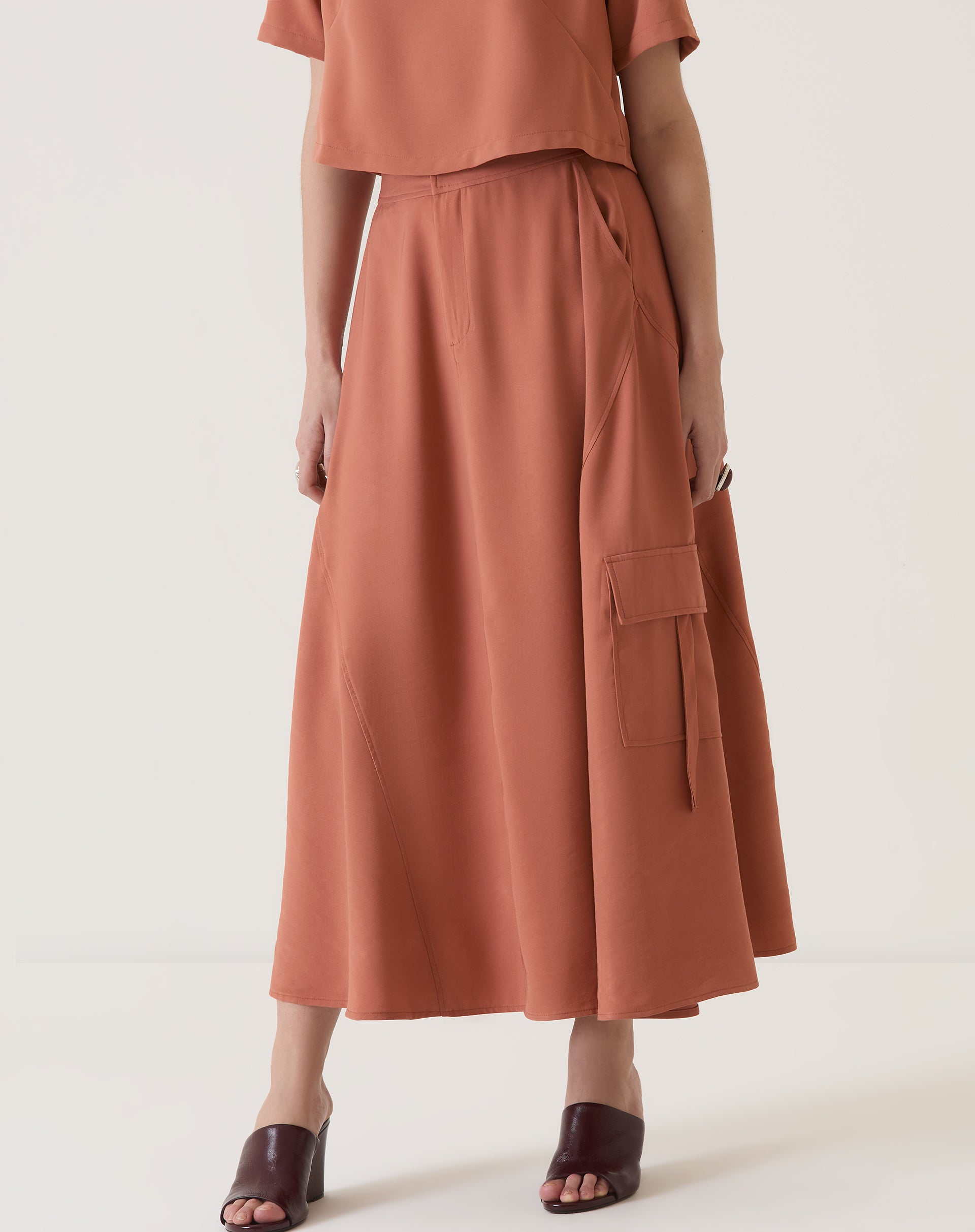 Imagem da saia midi bege com bolsos cargo, vista frontal completa.