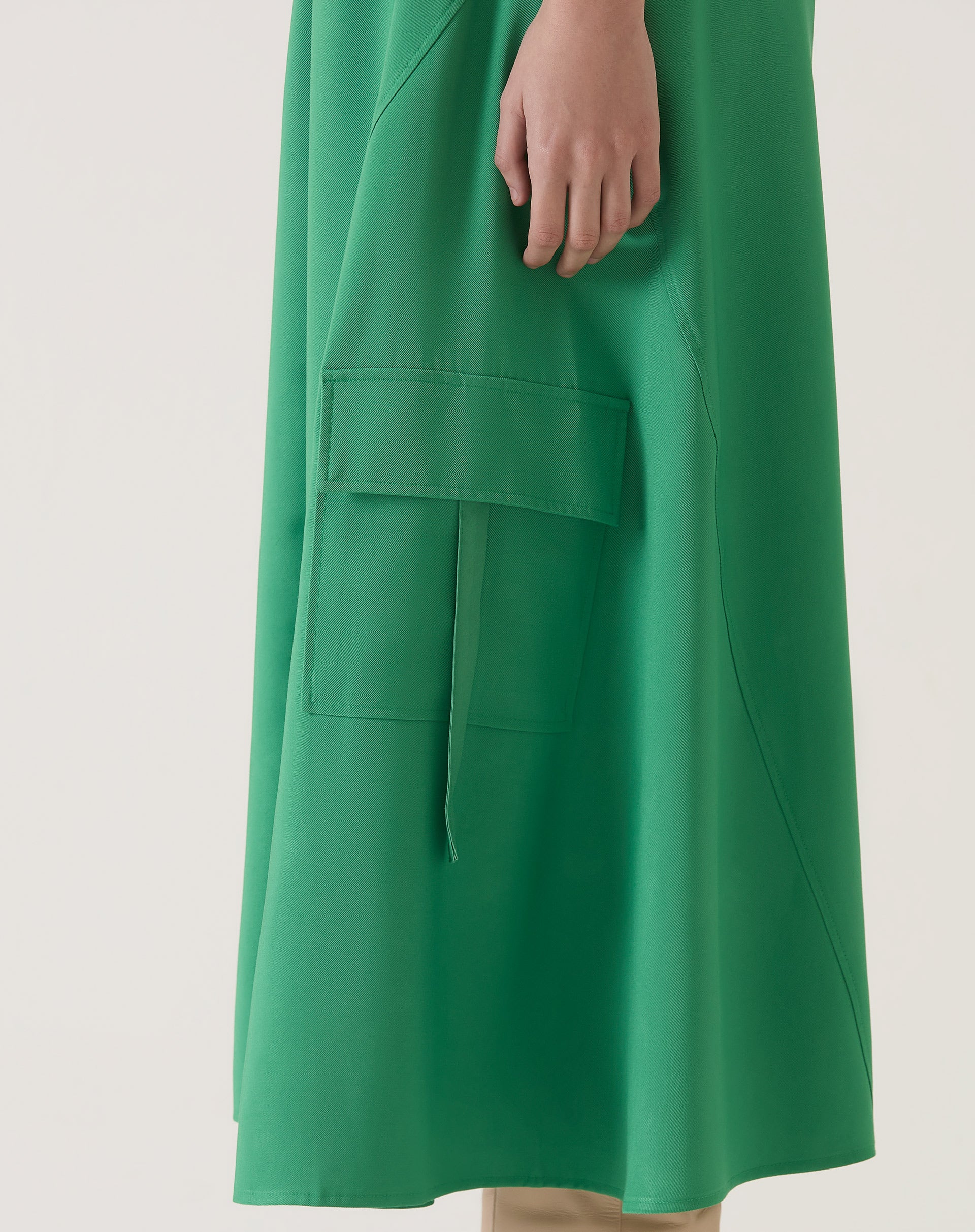 Vista lateral da saia verde com bolsos cargo.