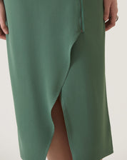 Detalhe da fenda frontal do vestido verde em crepe.