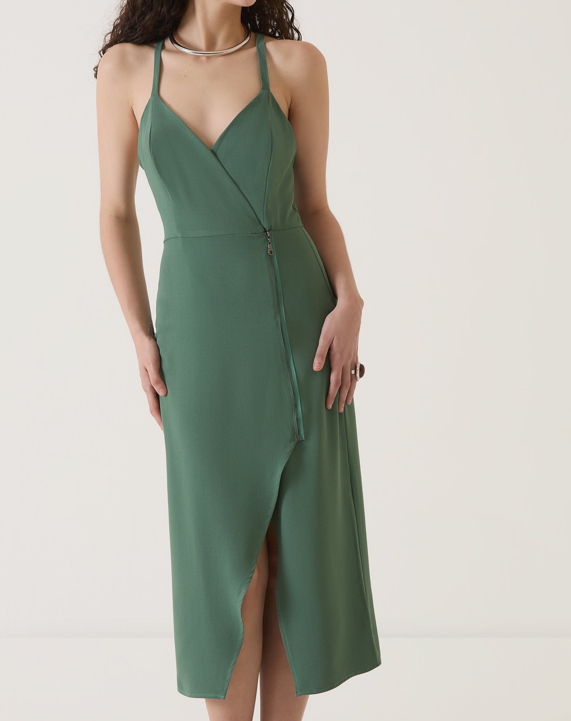 Vista frontal do vestido verde mostrando a fenda e o ajuste ao corpo.