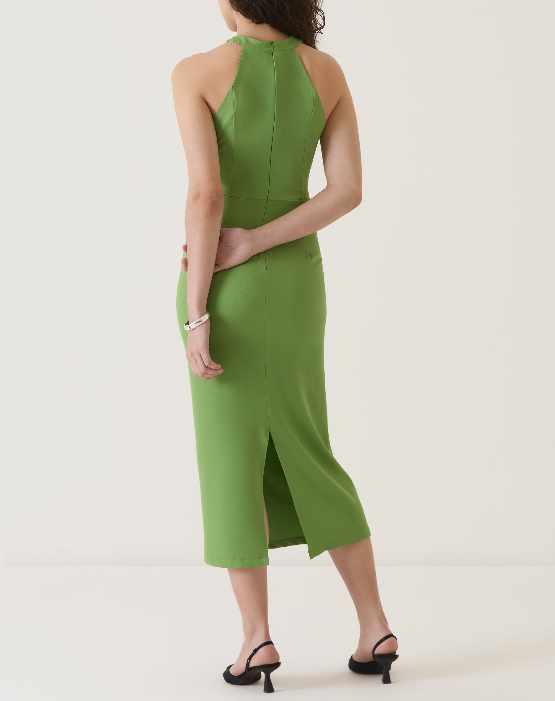 Vista traseira do vestido verde com detalhe de fenda na barra.
