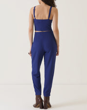 Vista traseira da blusa azul com alças, mostrando o ajuste sob medida e o comprimento cropped.