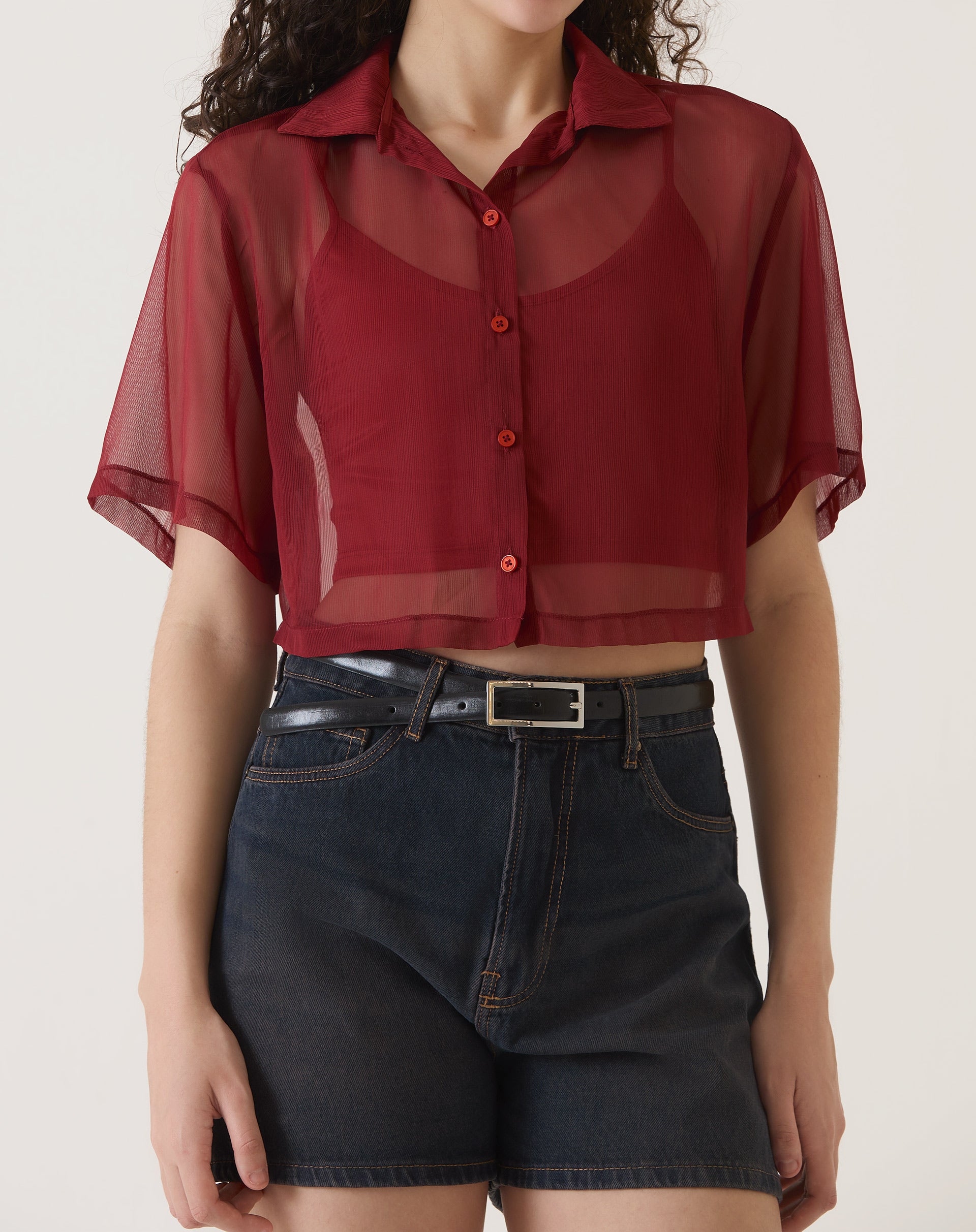 Vista frontal da camisa manga curta vinho, mostrando seu comprimento curto e gola.