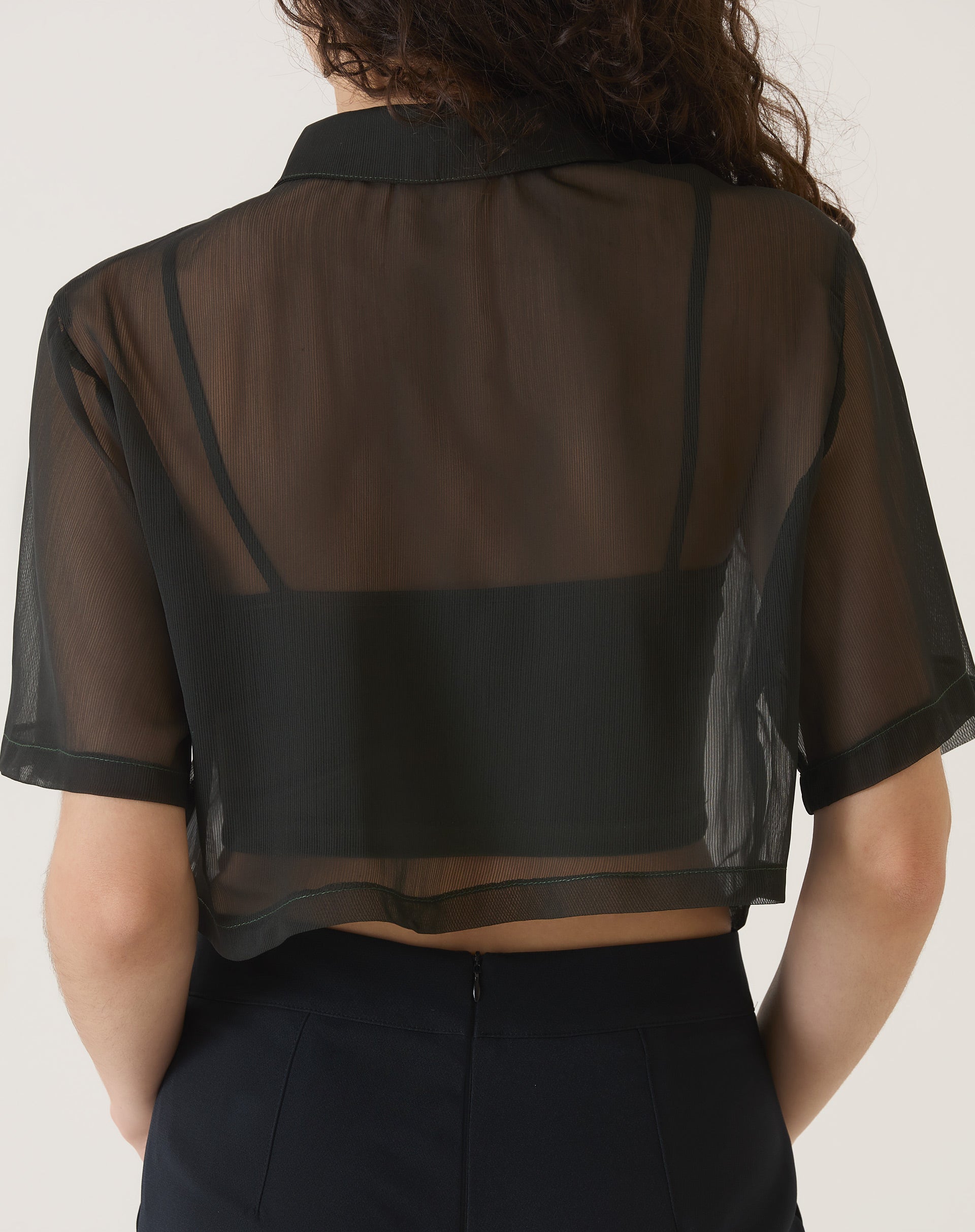 Vista traseira da camisa manga curta preta mostrando o design transparente.