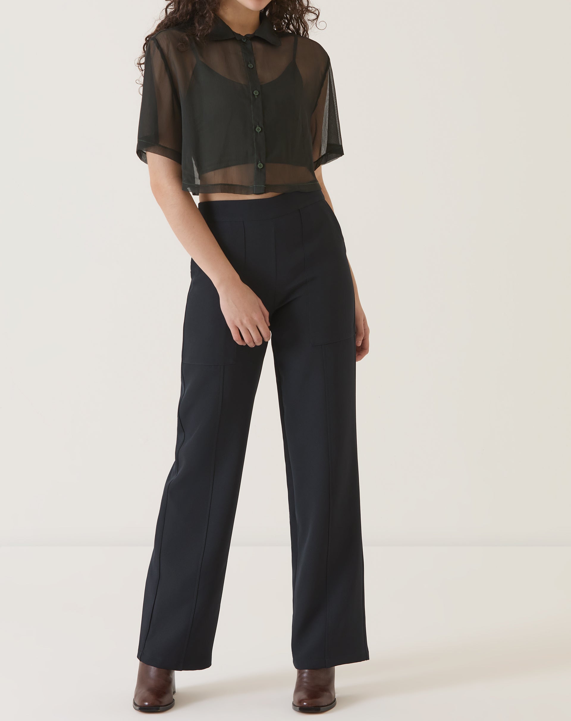 Modelo vestindo camisa manga curta preta com calça preta.