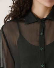 Detalhe do colarinho e fechamento frontal com botões da camisa preta.