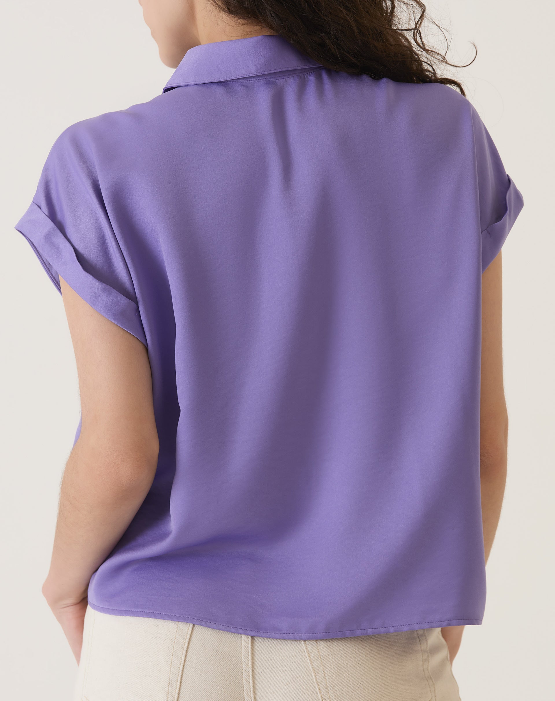 Vista traseira da camisa de cetim roxa mostrando o caimento solto.