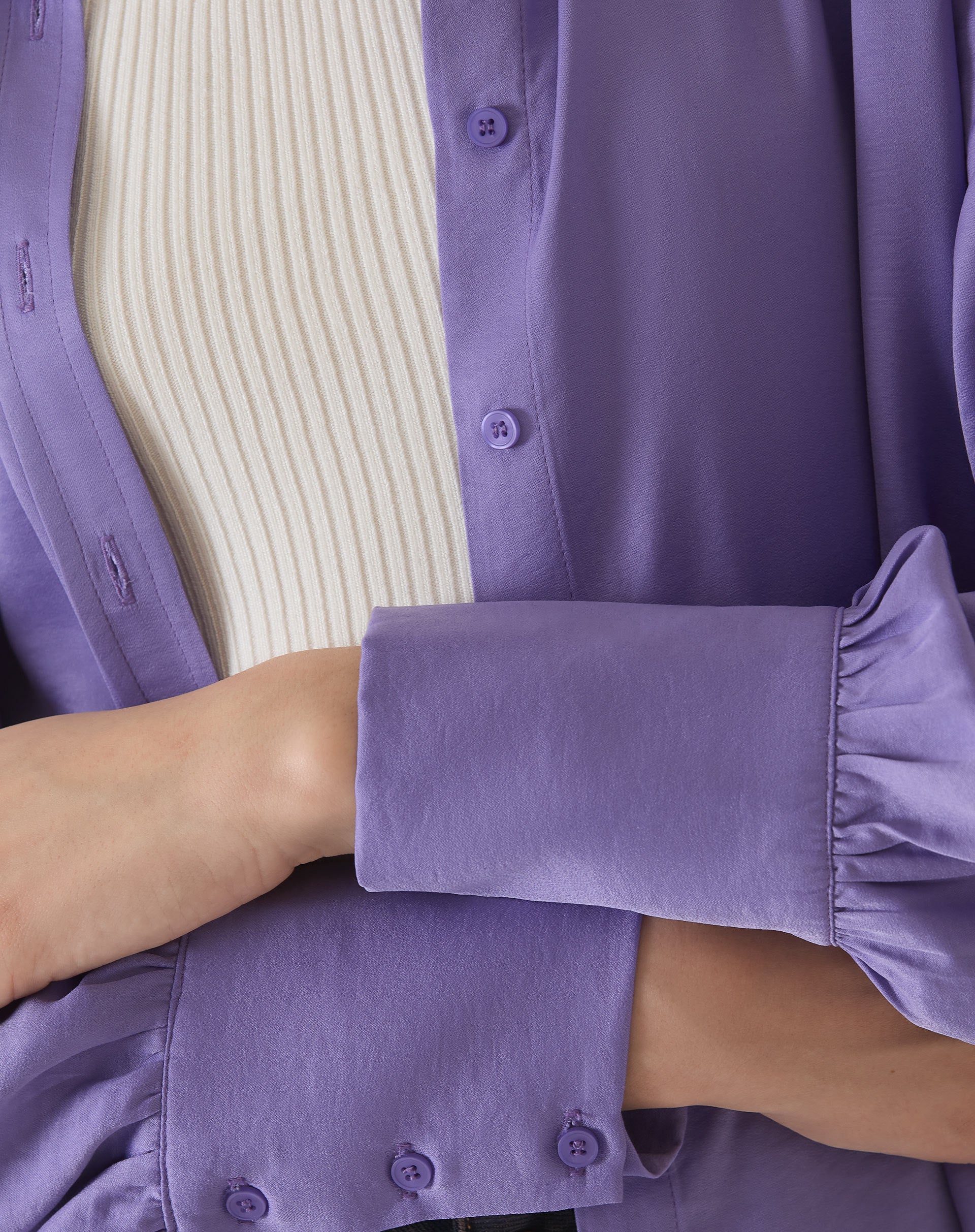 Detalhe do tecido e botões da camisa de cetim roxo.