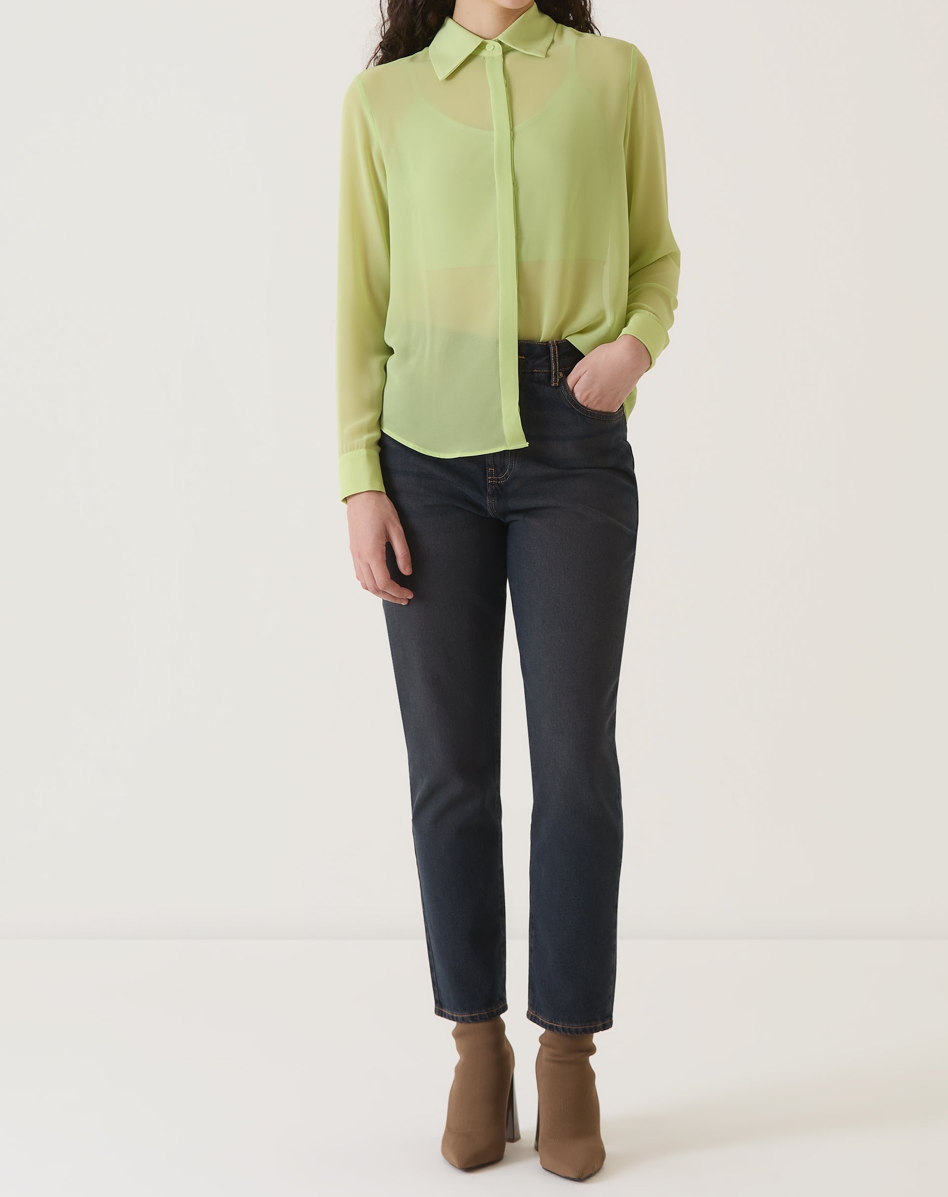 Vista completa da camisa verde com transparência, combinada com calça.