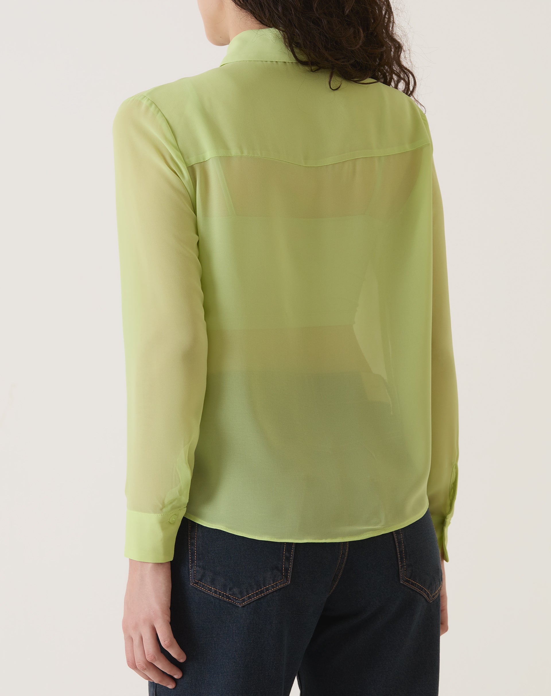 Vista traseira da camisa verde com transparência, mostrando detalhes.