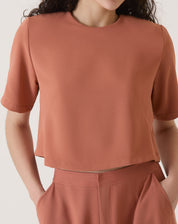 Blusa cropped manga curta em crepe de poliéster na cor vinho, vista frontal.