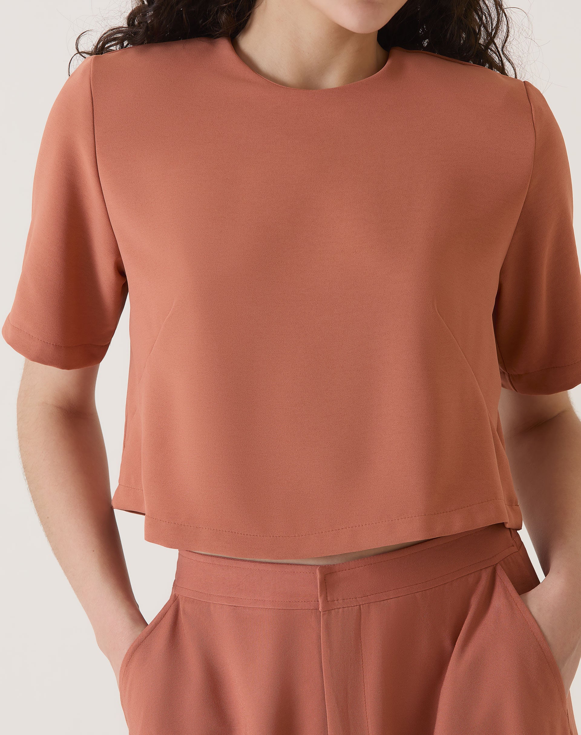 Blusa cropped manga curta em crepe de poliéster na cor vinho, vista frontal.