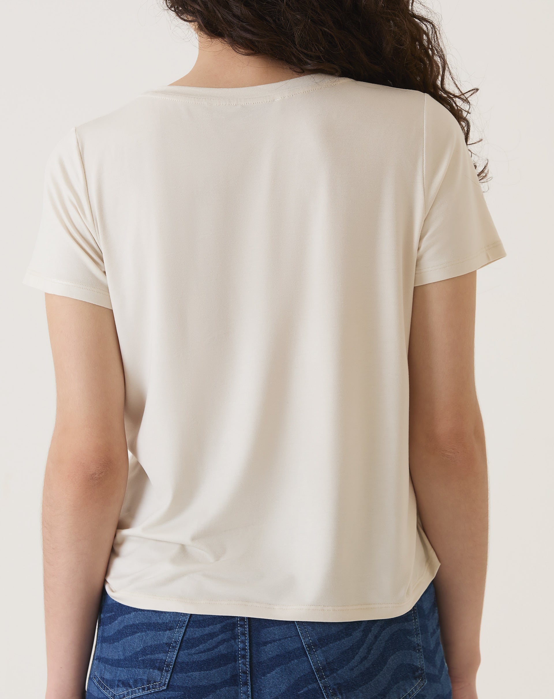 Vista traseira da camiseta de malha na cor areia.