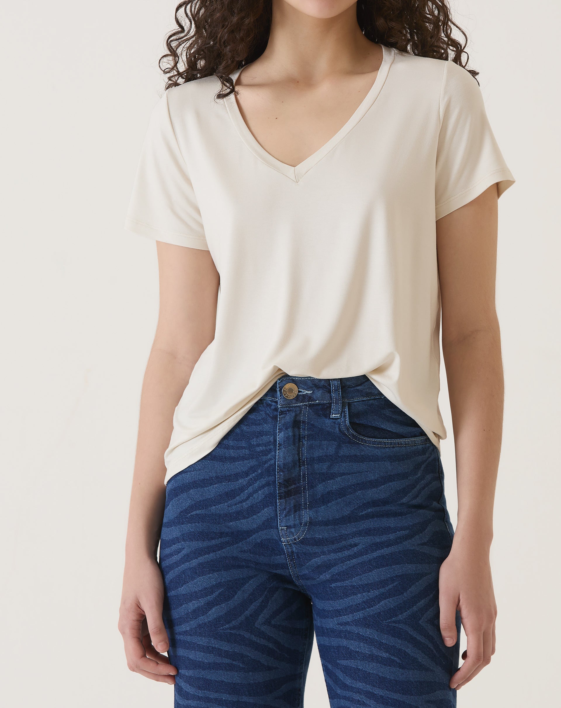 Camiseta de malha com decote em V na cor areia, vista frontal.