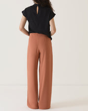 Vista traseira da calça de alfaiataria terracota.