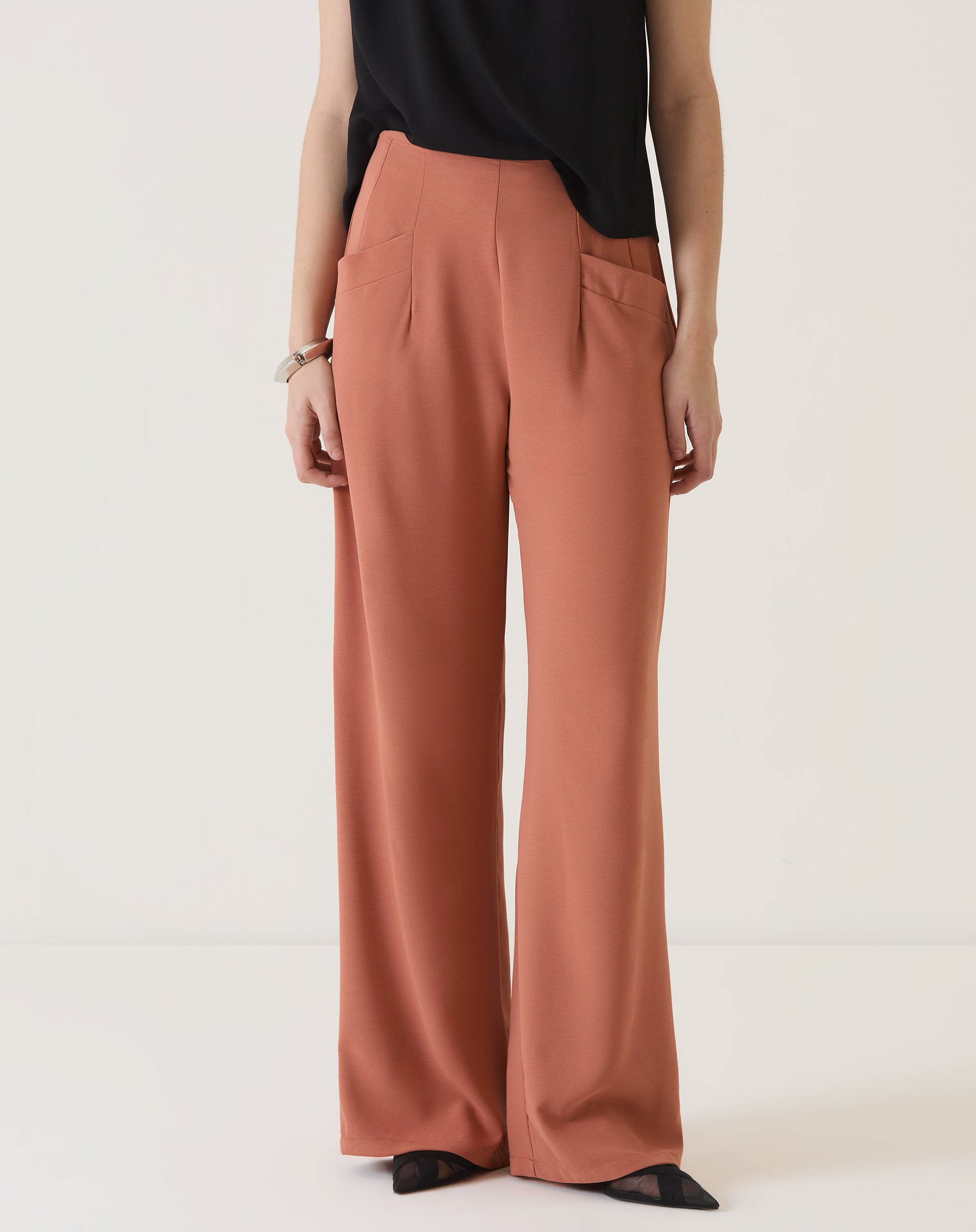 Vista frontal completa da calça de alfaiataria terracota.