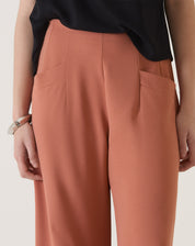 Detalhe dos bolsos da calça de alfaiataria terracota.