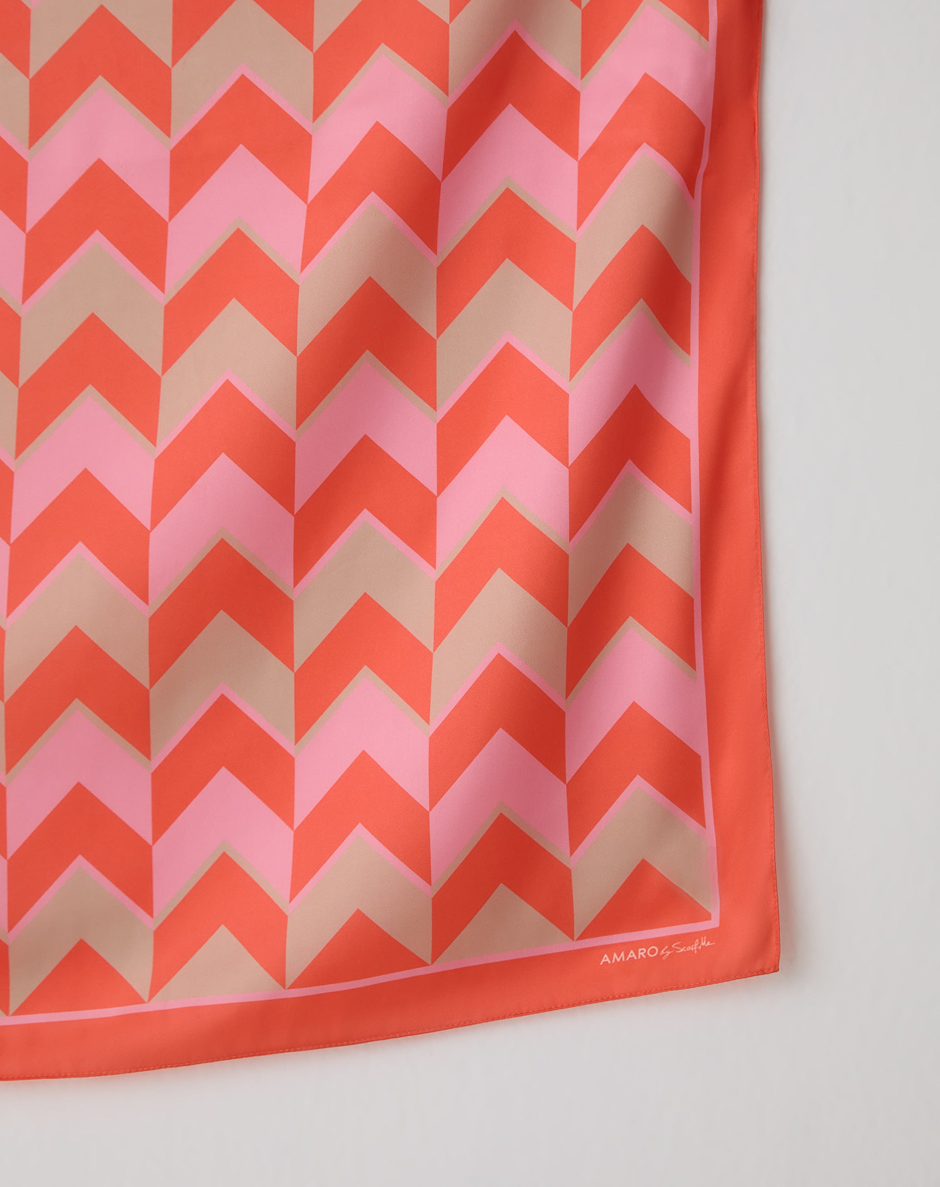 Detalhe do drapeado do tecido do lenço AMARO com padrão chevron e caimento acetinado, mostrando textura e fluidez