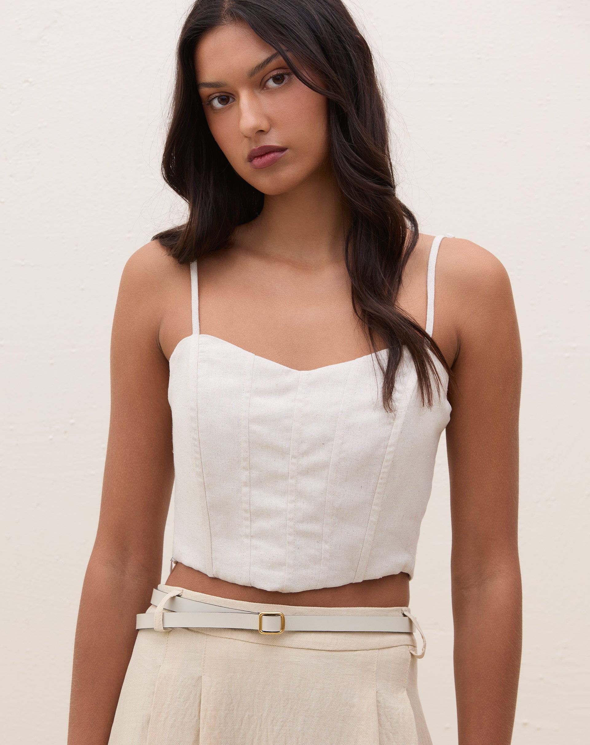 Top de alcinha estruturado cor areia visto de frente em modelo, cropped com alças finas