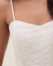 Close-up do corpete do top mostrando costuras verticais estruturantes e textura do tecido areia