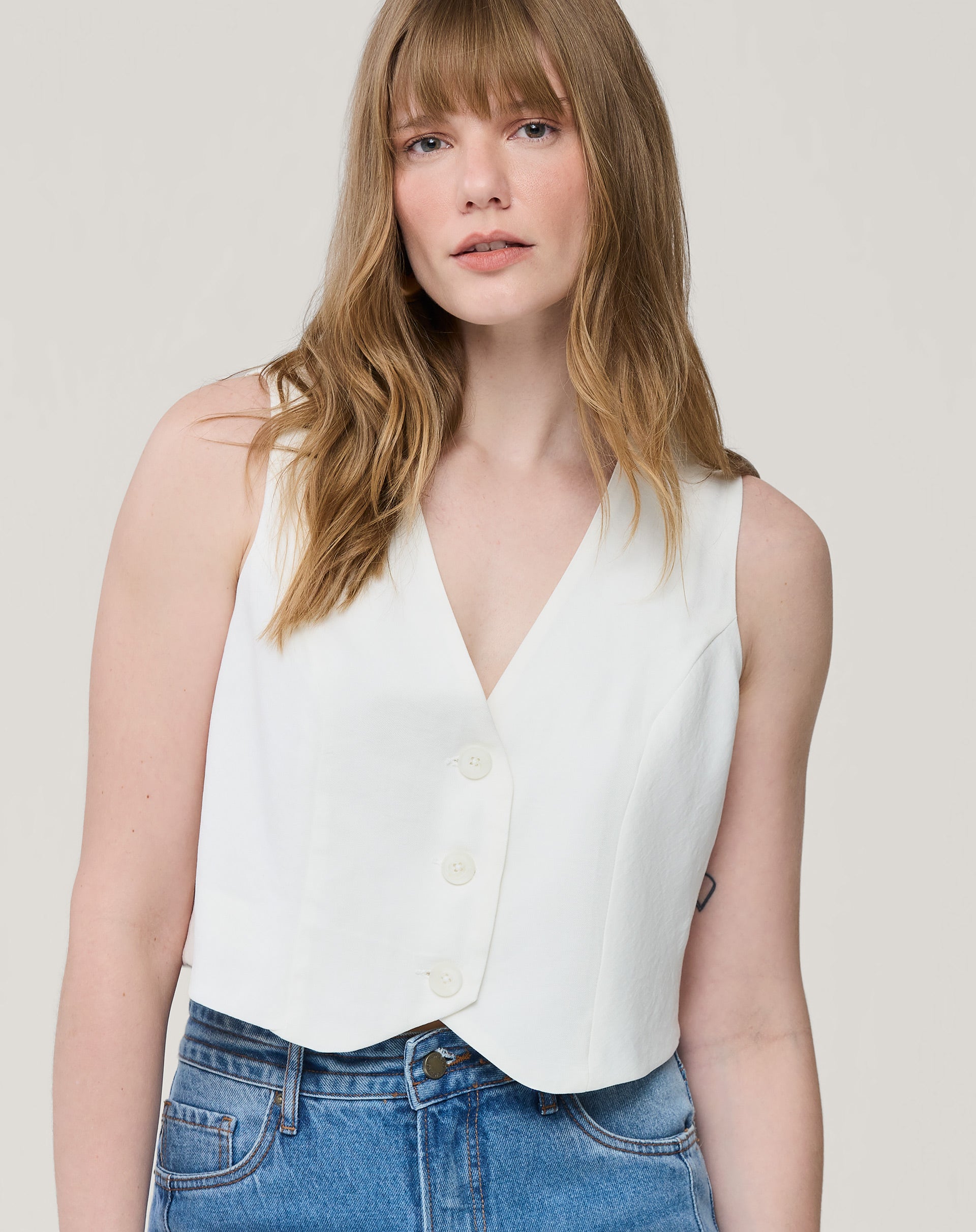 Colete cropped branco com decote em V e botões frontais, vista frontal aplicativo de moda - colete branco minimalista